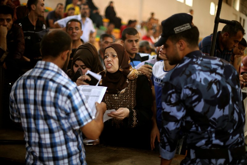 © Reuters. People ask for travel permits to cross into Egypt through the Rafah border crossing after it was opened by Egyptian authorities on Wednesday for five days, in the southern Gaza Strip