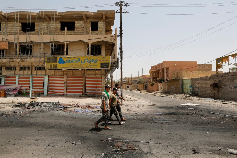 © Reuters. Iraqi security forces walk in Falluja, Iraq, after government forces recaptured the city from Islamic State militants