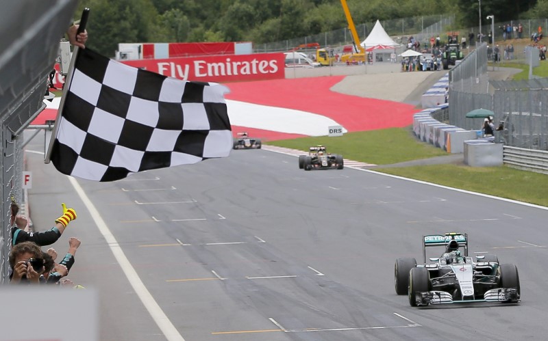 © Reuters. Mercedes driver Nico Rosberg takes the chequered flag to win the Austrian F1 Grand Prix in Spielberg