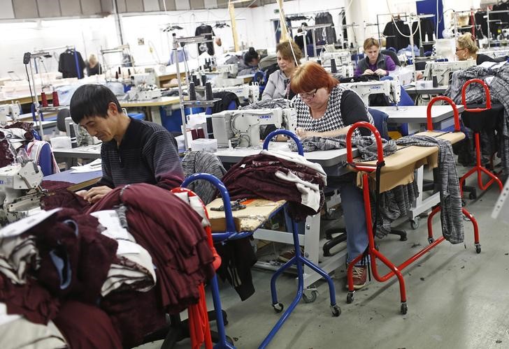 © Reuters. Employees work on sewing machines at the Fashion Enter factory in London