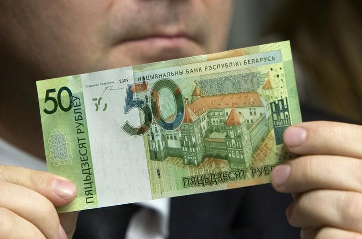 © Reuters. Заместитель председателя правления Нацбанка Белоруссии Дмитрий Лапко показывает образец новой банкноты на пресс-конференции в Минске