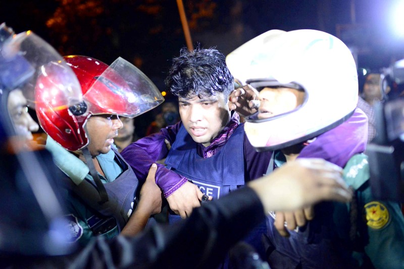 © Reuters. Policial ferido é carregado por colegas após atirador abrir fogo em restaurante em região diplomática de Daca, em Bangladesh