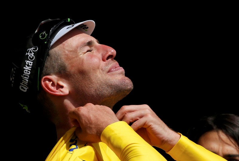 © Reuters. El ciclista británico Mark Cavendish se coloca el maillot amarillo de líder del Tour de Francia al término de la primera etapa entre Mont Saint-Michel y Utah Beach.