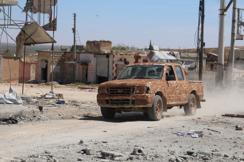 © Reuters. A muddied military vehicle drives on a street after Syrian rebels and the al Qaeda-affiliated Nusra Front took control of al-'Iss town, in Aleppo countryside