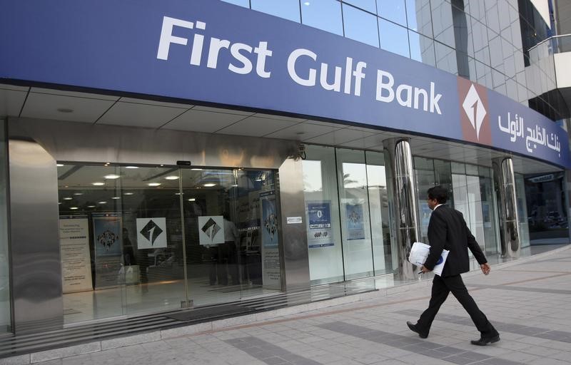 © Reuters. A man walks into a branch of First Gulf Bank along Khalid Bin Al-Waleed Road