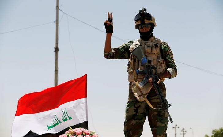 © Reuters. A member of Iraqi government forces reacts to the camera in Falluja