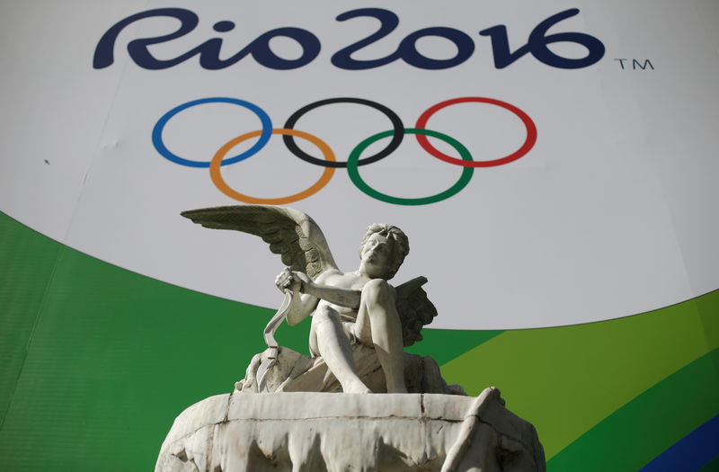 © Reuters. A giant banner advertising the 2016 Rio Olympics is pictured behind a statue outside a tunnel which connects Botafogo and Copacabana neighbourhoods in Rio de Janeiro