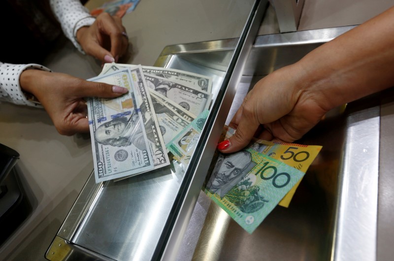 © Reuters. Australian dollar and U.S. dollar denominations are shown in a photo illustration at a currency exchange in Sydney