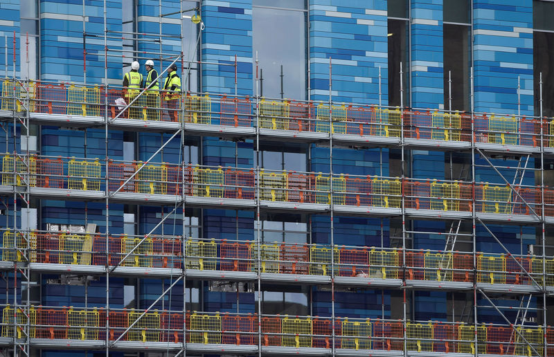 © Reuters. Workers stand on scaffolding on a new residential building at Battersea in London, Britain