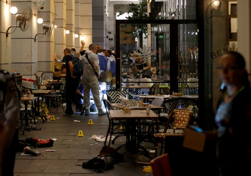 © Reuters. Israeli policemen work inside a restaurant following a shooting attack that took place in the center of Tel Aviv