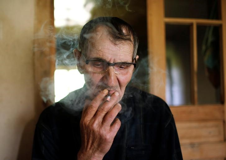 © Reuters. Темур Батирашвили курит в своем доме в деревне Биркиани