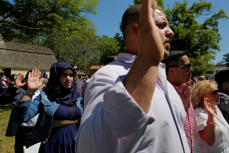 © Reuters. Kaltouma Jamali of Morocco takes the Oath of Allegiance as she and 145 others become United States citizens during a naturalization ceremony at Old Sturbridge Village in Sturbridge