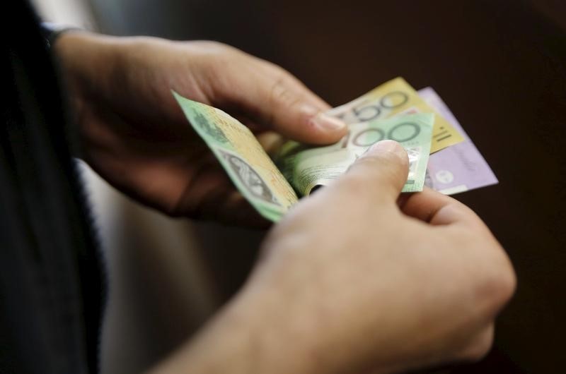 © Reuters. A customer counts his Australian dollar banknotes at an exchange office in downtown Cairo