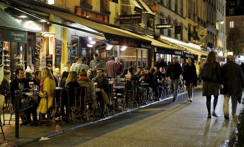 © Reuters. People sit at tables outside a bistro in Paris