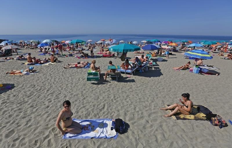 © Reuters. People sunbath at Ostia beach, west of Rome