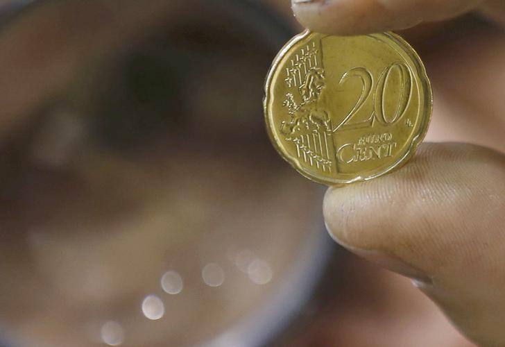 © Reuters. An employee inspects a 20 cent euro coin after it was minted at the"Monnaie de Paris" national mint factory in Pessac