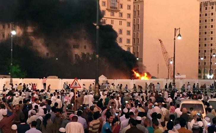 © Reuters. Muslim worshippers gather after a suicide bomber detonated a device near the security headquarters of the Prophet's Mosque in Medina