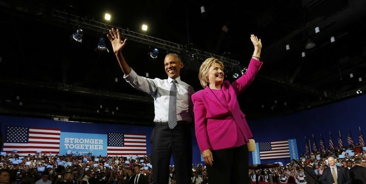 © Reuters. Presidente dos Estados Unidos, Barack Obama, acena para a multidão ao lado da candidata democrata à Presidência dos EUA, Hillary Clinton, durante comício de campanha em Charlotte