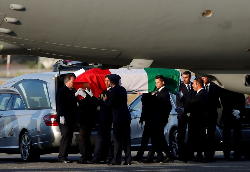 © Reuters. A coffin containing the body of one of the nine Italians killed in the Bangladesh attack is carried by pallbearers as it is disembarked from an Italian airplane at Ciampino military airbase