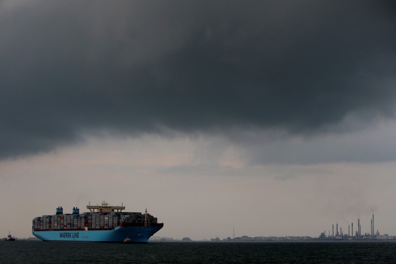 © Reuters. The MV Maersk Mc-Kinney Moller is led by pilot ships as it makes its maiden port of call at a PSA International port terminal in Singapore