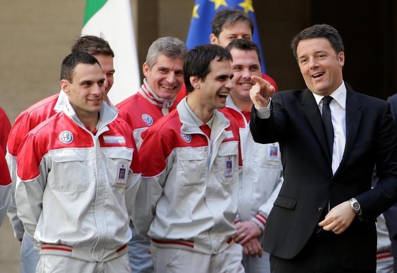 © Reuters. Il premier Matteo Renzi scherza con alcuni lavoratoi di Alfa Romeo alla presentazione della nuova auto Giulia a Palazzo Chigi