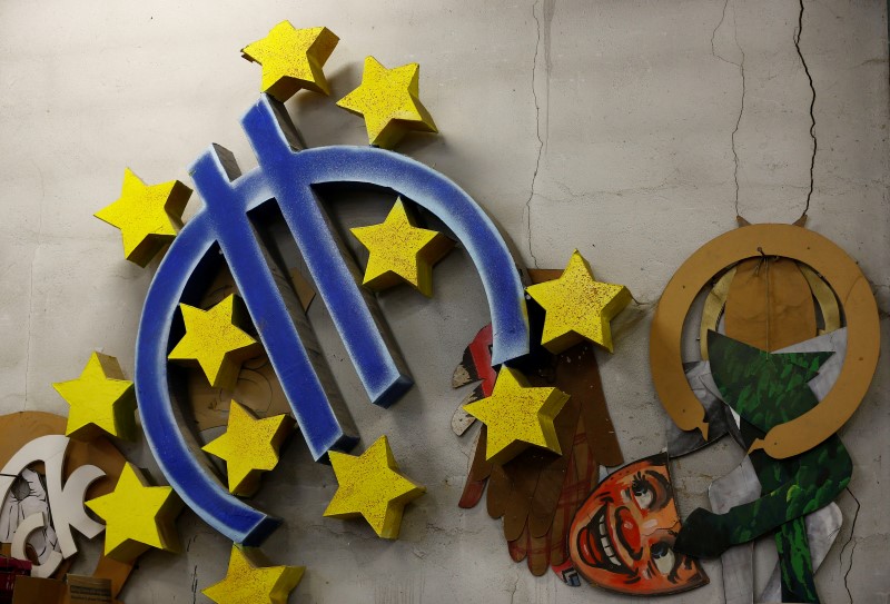 © Reuters. A carnival float euro sign decoration, leftover from previous years, hangs on a wall in a carnival workshop in Mainz