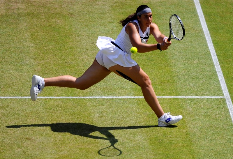 © Reuters. Marion Bartoli of France hits a return to Sabine Lisicki of Germany during their women's singles final tennis match at the Wimbledon Tennis Championships, in London