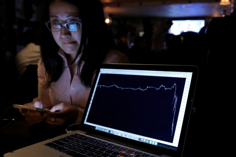 © Reuters. A woman watching the Brexit vote in The Churchill Tavern reacts as a graph shows the British Pound falling in value following the announcement that Britain would leave the European Union, in New York