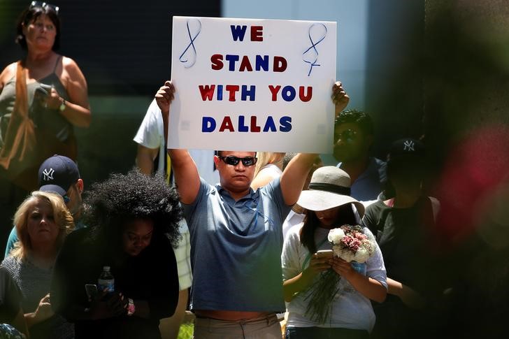 © Reuters. Homen segura cartaz durante vigília após ataque a contra policiais em Dallas, Texas