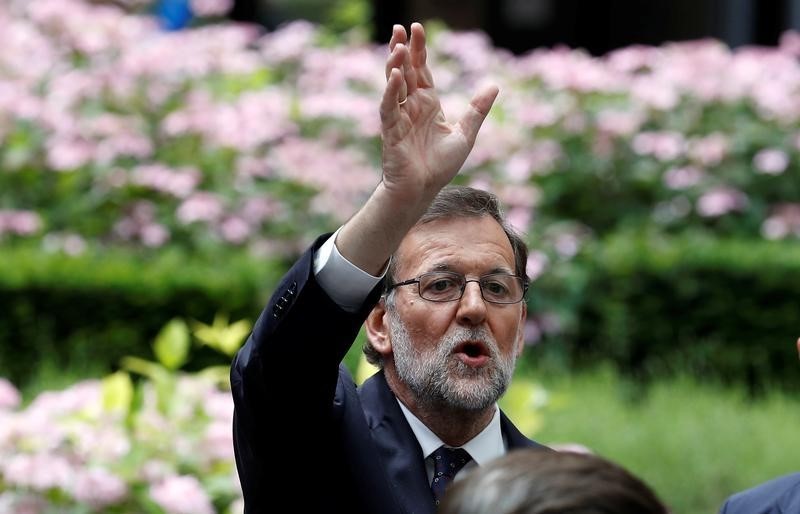 © Reuters. Spanish Prime Minister Mariano Rajoy waves as he waits for his car at the end of the second day of the EU Summit in Brussels