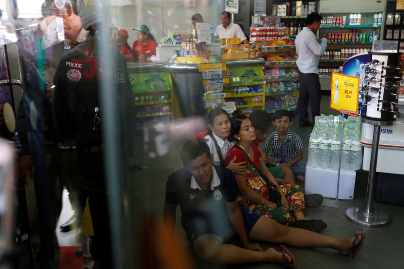 © Reuters. Relatives of Kem Ley, anti-government figure and the head of a grassroots advocacy group, "Khmer for Khmer" sit inside a gas station after he was shot dead in Phnom Penh