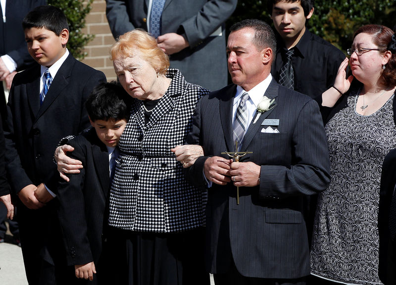 © Reuters. Rosemarie Colvin, the mother of journalist Marie Colvin, embraces a youth as her casket is is carried out of her funeral service as her looks on at St. Dominic's Church in Oyster Bay, New York