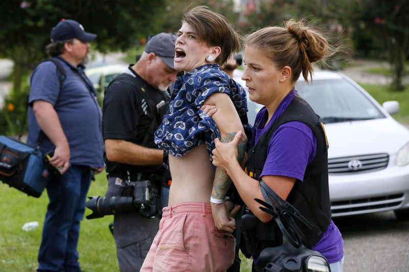 © Reuters. A demonstrator protesting the shooting death of Alton Sterling is detained by a law enforcement officer in Baton Rouge