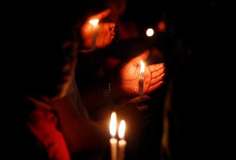 © Reuters. People attend a candle light vigil for the victims of the attack on the Holey Artisan Bakery and the O'Kitchen Restaurant, in Dhaka