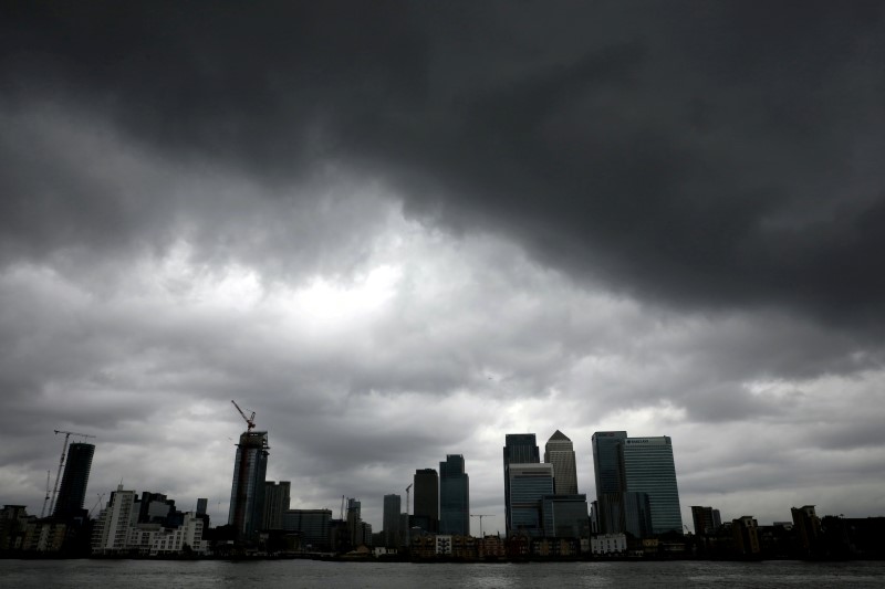 © Reuters. Rain clouds pass over the Canary Wharf financial district in London