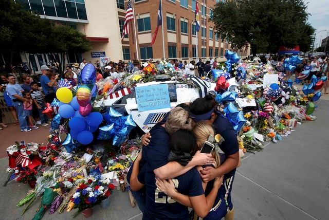 © Reuters. Pessoas em frente memorial às vítimas de ataque em Dallas