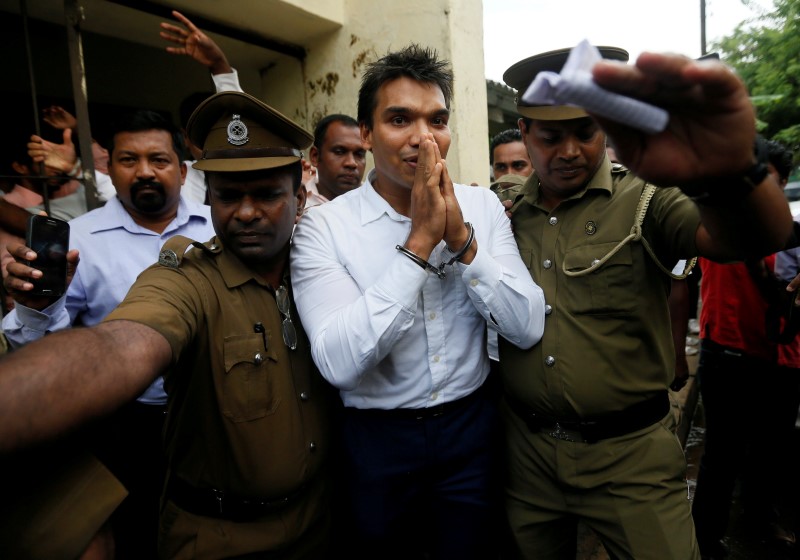© Reuters. Namal Rajapaksa, son of former Sri Lanka's President Mahinda Rajapaksa, leaves with prison officers at the court after being arrested in Colombo