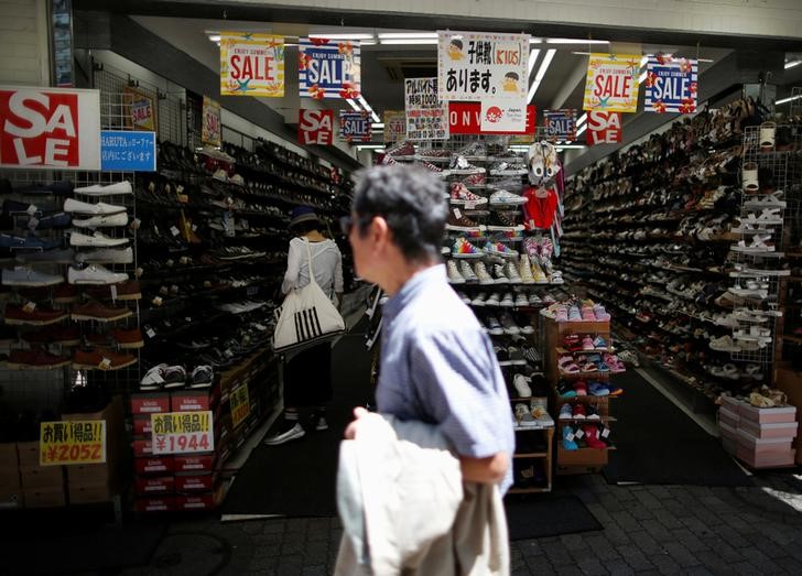 © Reuters. A shopper checks items inside a shoes shop at Shibuya shopping and amusement district in Tokyo, Japan
