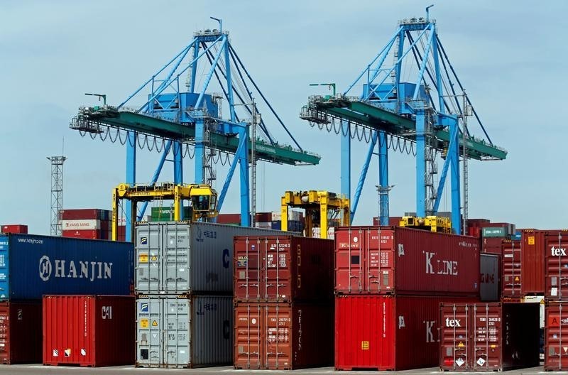 © Reuters. Cranes move shipping containers stacked along the dockside at the Seayard Co. terminal, operated by the Marseille-Fos port authority in Fos sur Mer