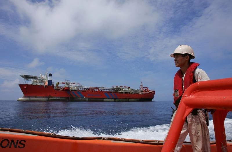 © Reuters. A worker rides in a speedboat off Bluewater's floating production, storage and offloading (FPSO) ves..