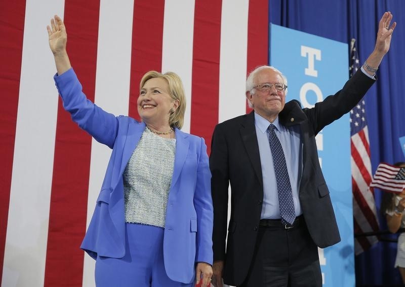 © Reuters. Candidata democrata à Presidência dos EUA, Hillary Clinton (E), ao lado do senador Bernie Sanders (D) em comício de campanha em Portsmouth, New Hampshire