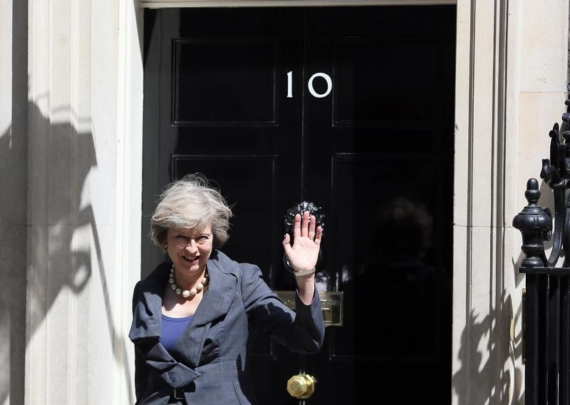 © Reuters. Britain's Home Secretary Theresa May, who is due to take over as prime minister on Wednesday, waves as she leaves after a cabinet meeting at number 10 Downing Street, in central London, Britain