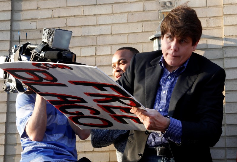 © Reuters. Former Governor of Illinois Blagojevich signs autographs on his front porch after making a statement to reporters outside his Chicago home one day before reporting to federal prison in Colorado to serve a 14-year sentence for corruption