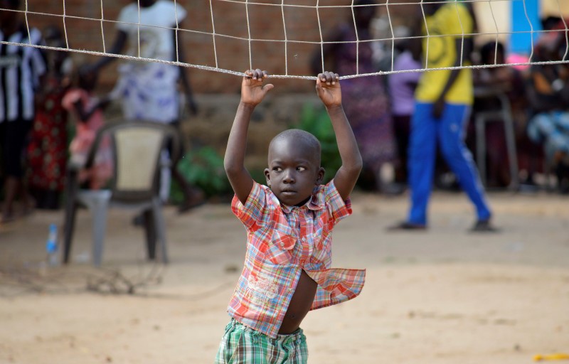 © Reuters. A boy displaced in recent fighting plays on a volleyball net as they camp at the Anglican church compound in Juba, South Sudan