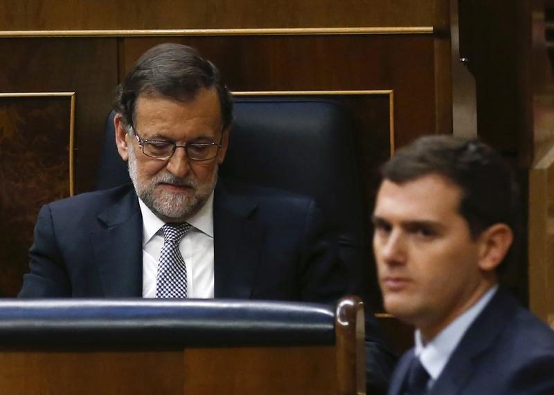 © Reuters. File photo of Ciudadanos party leader Rivera walking past People's Party leader Rajoy during an investiture debate at parliament in Madrid