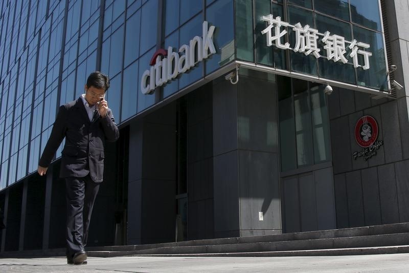 © Reuters. A man walks past a branch of Citibank in Beijing
