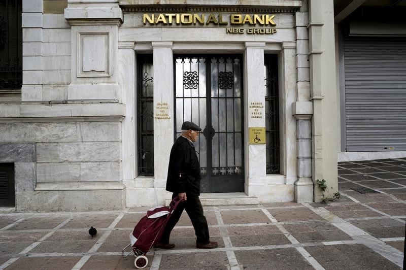 © Reuters. A man walks by a National Bank branch in Athens