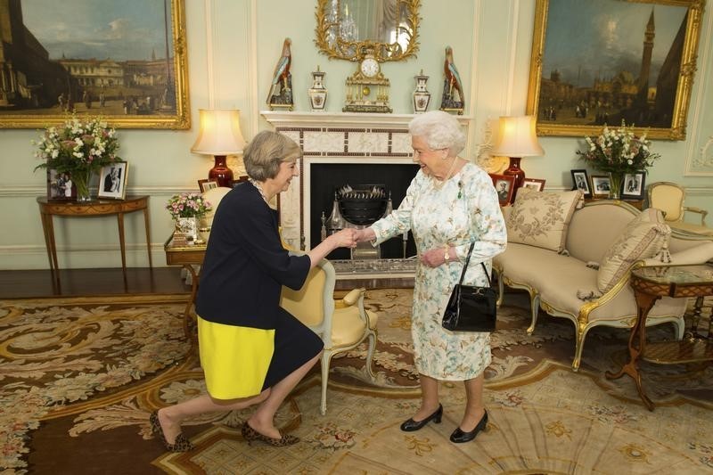 © Reuters. Rainha Elizabeth cumprimenta Theresa May no início de audiência no Palácio de Buckingham, em Londres