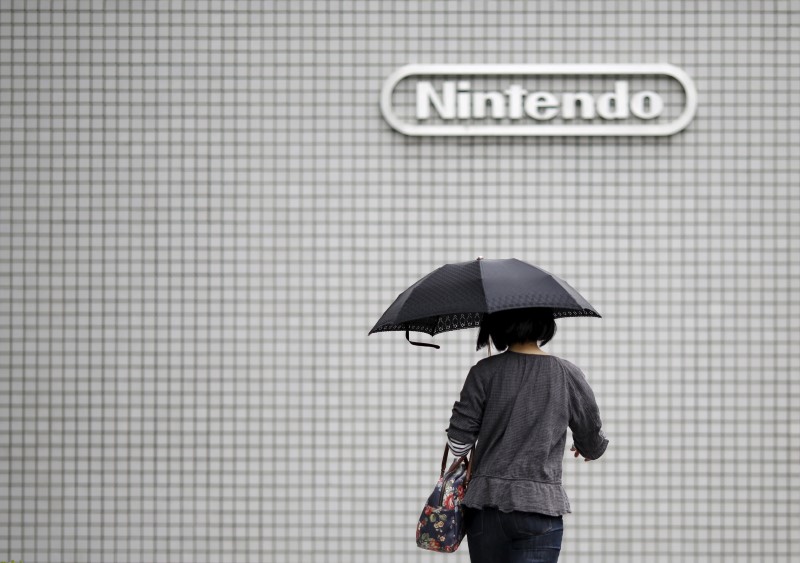 © Reuters. A woman walks past the logo of Nintendo Co Ltd in Tokyo