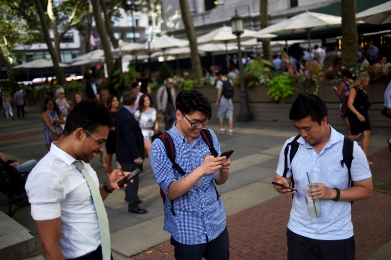 © Reuters. People play the augmented reality mobile game "Pokemon Go" by Nintendo in New York City